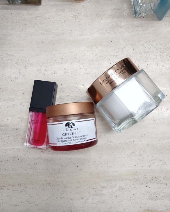 Zestaw kosmetyków dających efekt glow bez makijażu: Charlotte Tilbury Magic Cream, Origins GinZing i serum Whose That Lipstick.