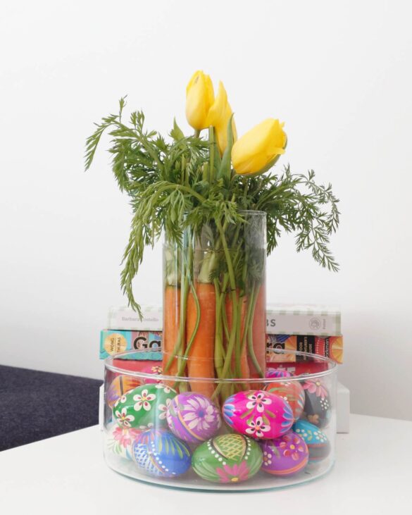 wielkanocna dekoracja stołu z marchewkami tulipanami i kolorowymi pisankami