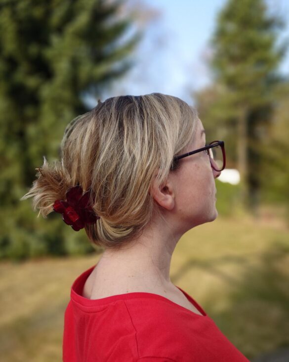 Profil kobiety z włosami blond do ramion, spiętymi klamrą w kok. Zdjęcie w świetle dziennym pokazuje blask i teksturę włosów po balejażu.