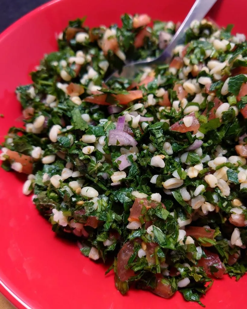 Tradycyjna arabska sałatka tabbouleh z mnóstwem pietruszki, pomidorami i kaszą bulgur