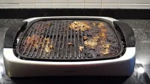 Brudny grill elektryczny z zapieczoną marynatą