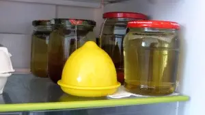 Butelki i słoiki z przygotowaną herbatą mrożoną w domowej lodówce