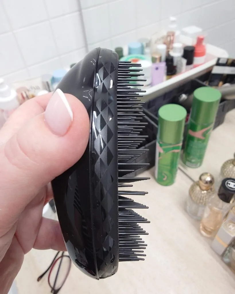 Zbliżenie profilu czarnej, nowej szczotki Tangle Teezer The Original. Pokazuje elastyczność polimerowych ząbków.